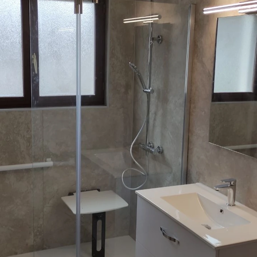 Salle de bain moderne avec douche à l'italienne vitrée, vasque blanche et miroir éclairé